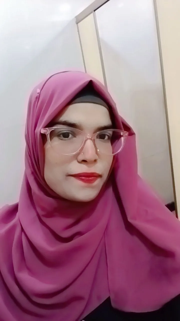 Happy young woman in graduation gown holding a certificate, celebrating success.