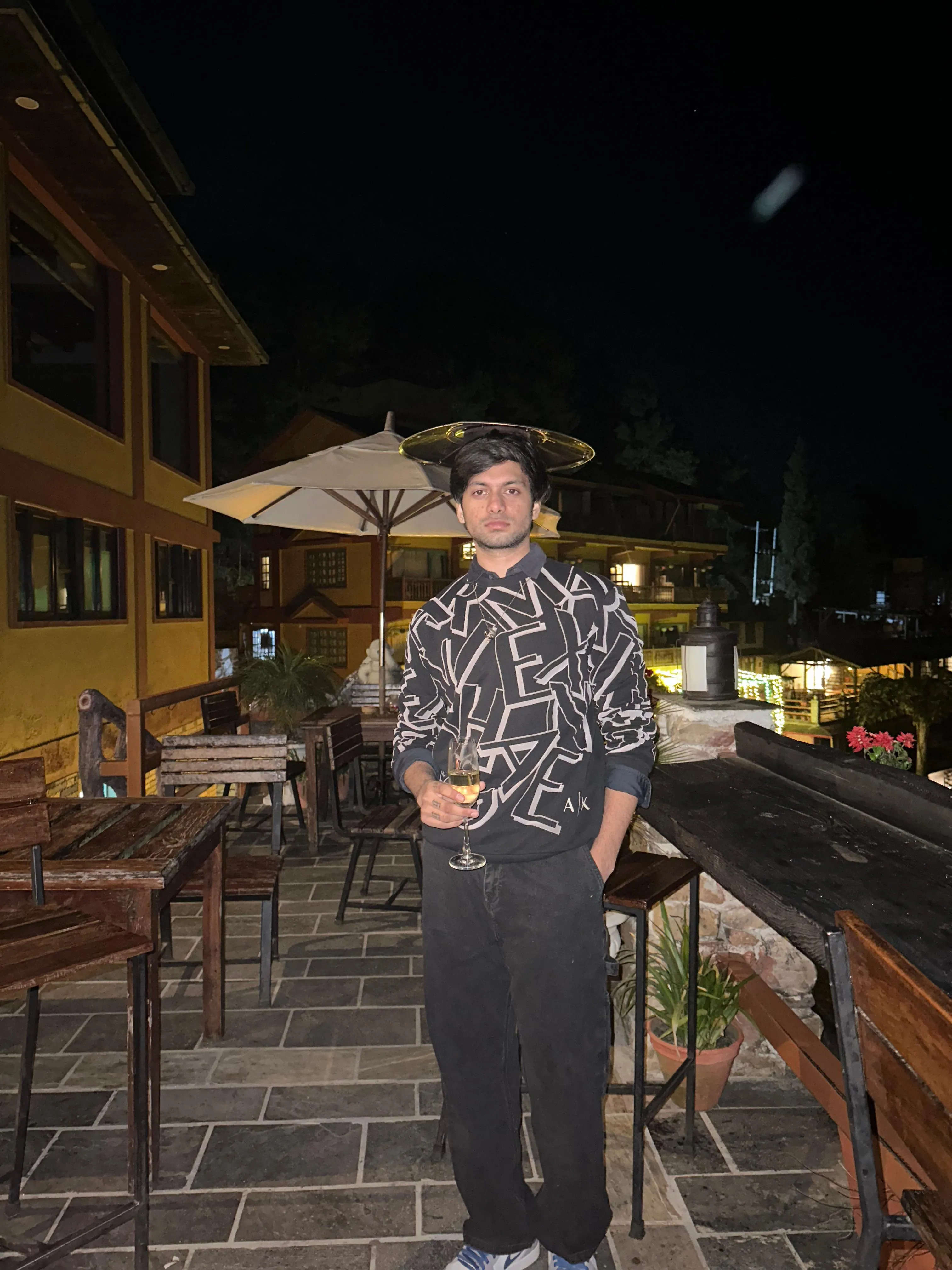 Black and white artistic portrait of a shirtless young man sitting against a clean background.