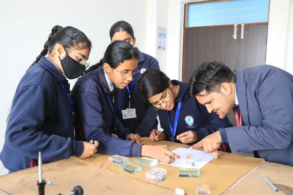 A teacher using a tablet in a bright classroom to explain a lesson to a student.