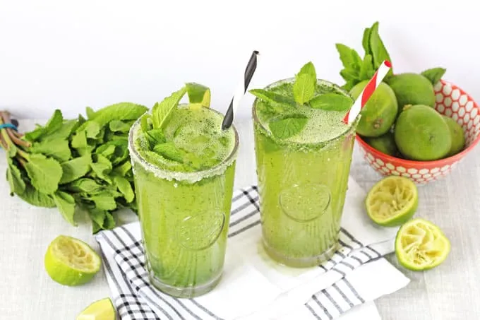 Colorful buffet table featuring mini burgers, pizza, and flowers at an outdoor event.