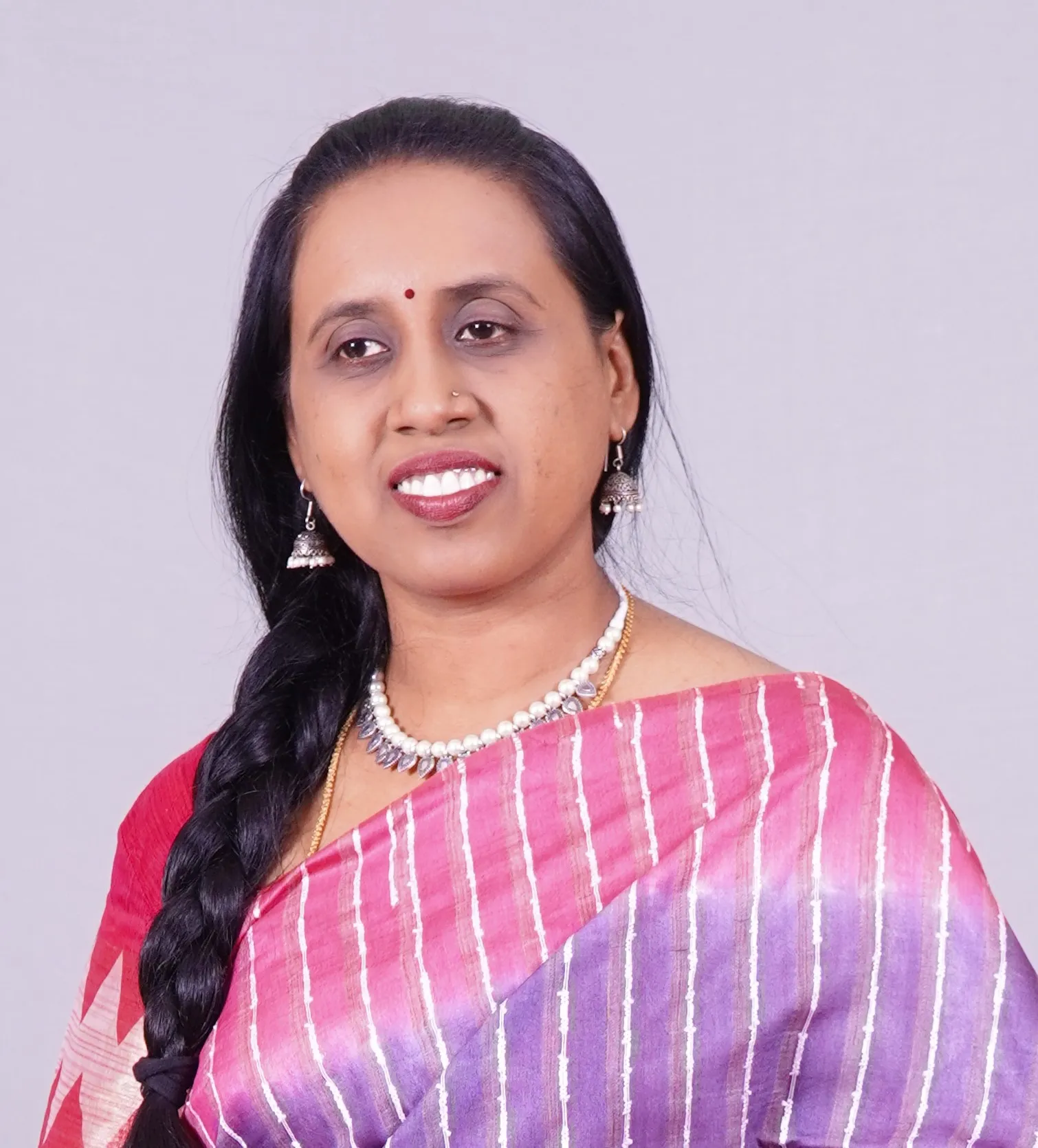 A young woman posing outdoors in Hanoi, showcasing modern street style with a natural backdrop.